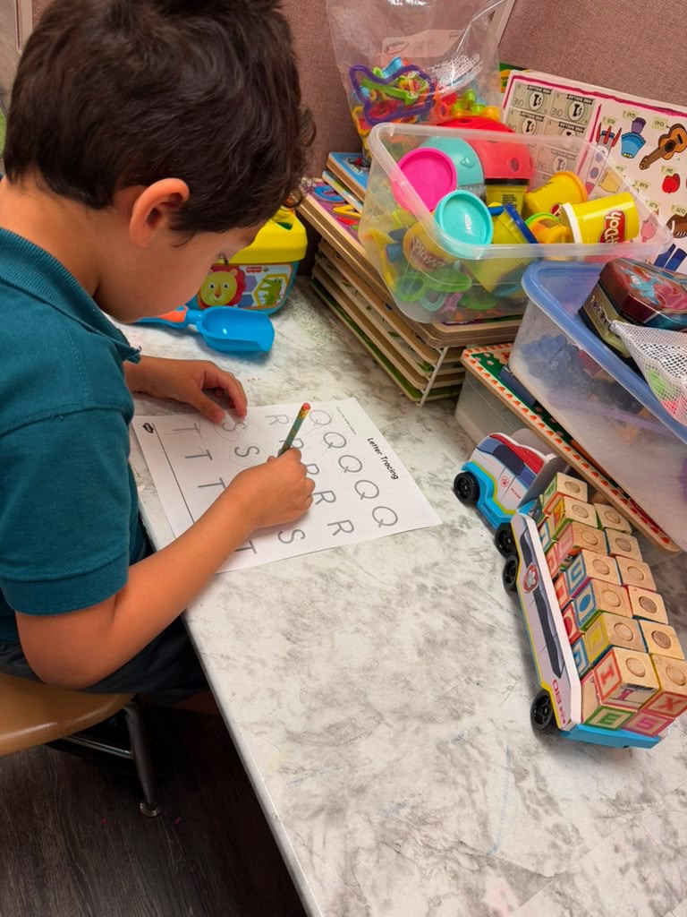 Child tracing letters during a speech and literacy focused therapy activity